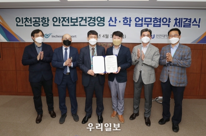 인천국제공항공사 회의실에서 열린 인천국제공항공사-인천대 간 산업안전 분야 산학협력 업무협약 체결식 에서 인천국제공항공사 이재곤 안전혁신실장(사진 가운데 왼쪽), 인천대 안전공학과 송창근 학과장(사진 가운데 오른쪽) 및 관계자들이 기념촬영을 하고 있다. ⓒ 인천공항공사 제공
