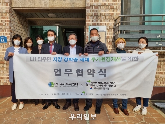 지난 10월 26일 LH 입주민 저장 강박증 세대 주거환경개선 지원사업을 협약체결하고 관계자들이 기념촬영을 하고 있다.