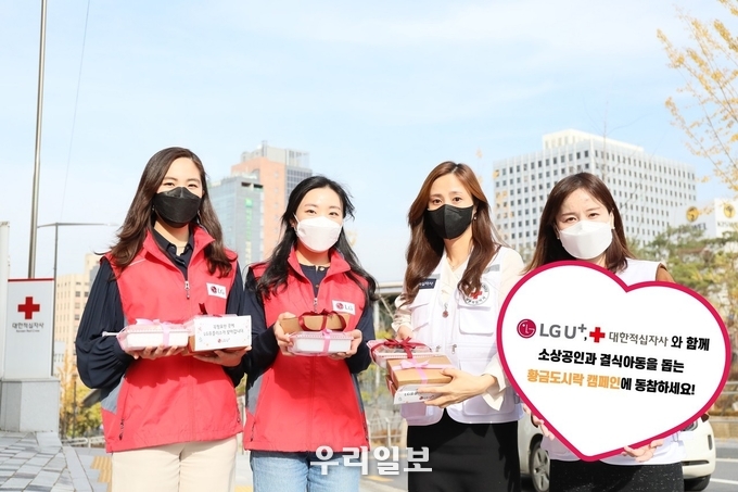 대한적십자사(회장 신희영)와 LG유플러스(대표 황현식) 임직원이 황금도시락 캠페인 론칭을 기념해 이를 소개하는 모습 