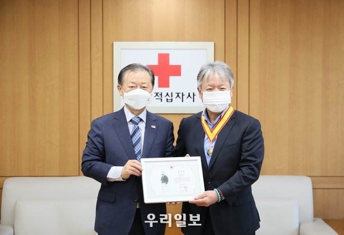 엄홍길 엄홍길휴먼재단 상임이사(사진 오른쪽)가 1일(수) 서울 중구 대한적십자사 서울사무소에서 열린 ‘적십자박애장 금장’ 전달식에서 대한적십자사 신희영 회장(왼쪽)으로부터 적십자박애장 금장을 받고 기념촬영을 하고 있다. 